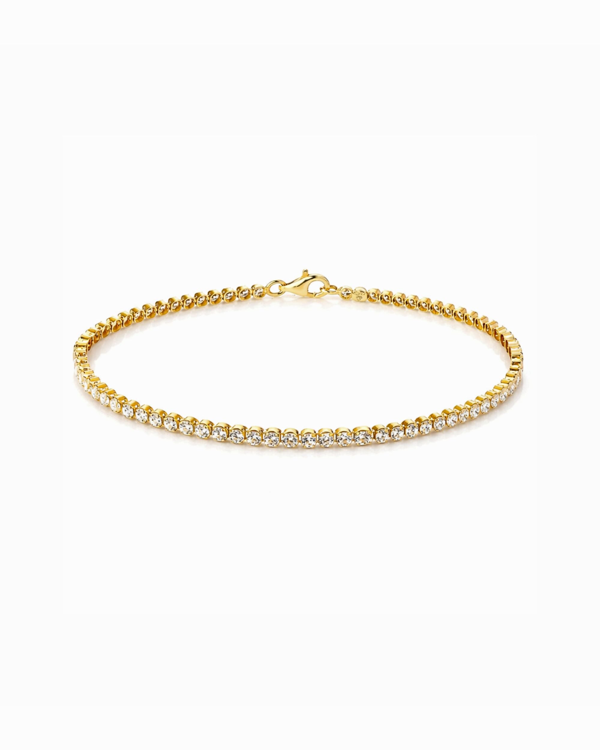 Gold bracelet with Cubic Zirconia stones on a white background