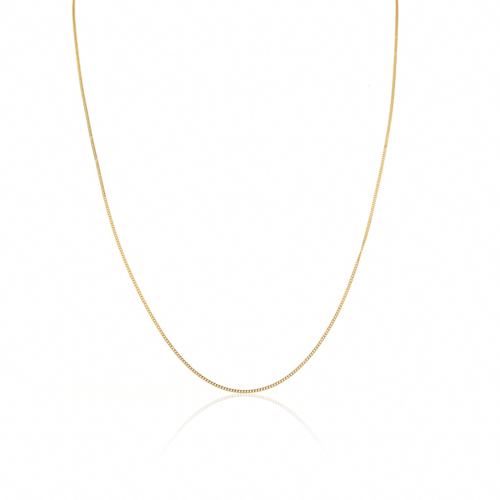 A delicate gold curb chain necklace displayed in a U-shape against a clean white background with a subtle reflection below.