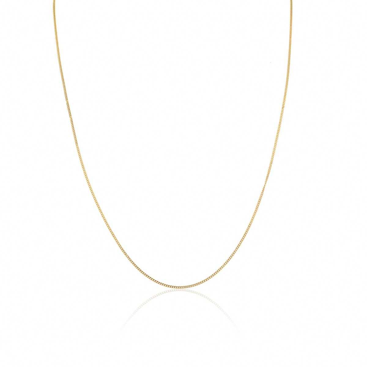 A delicate gold curb chain necklace displayed in a U-shape against a clean white background with a subtle reflection below.
