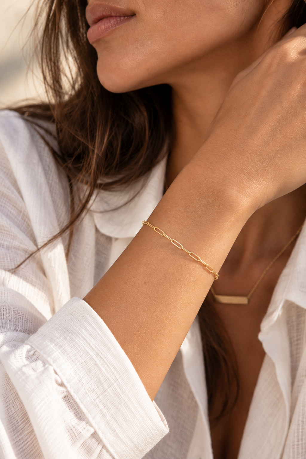 Model wearing a fine 9ct yellow gold paperclip bracelet
