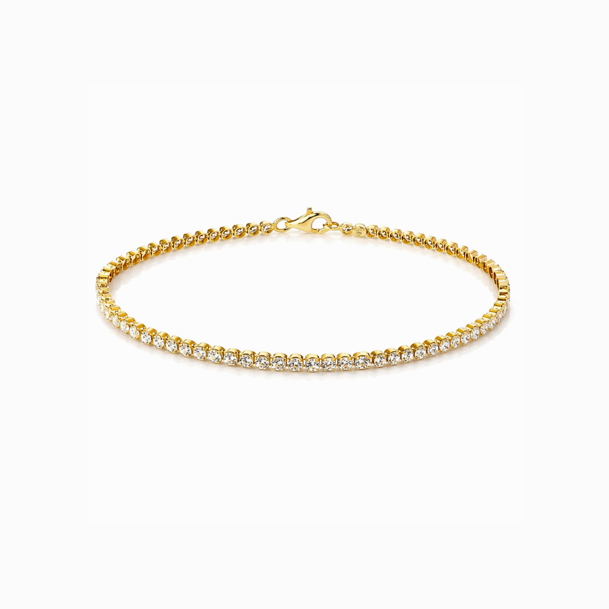 Gold bracelet with clear stones on a white background