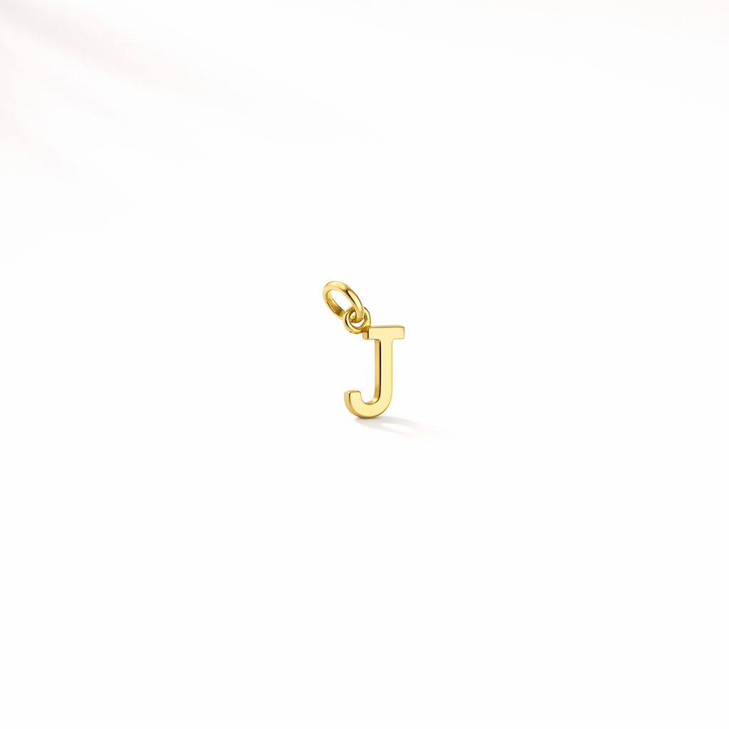 Gold 'J' pendant on a white background