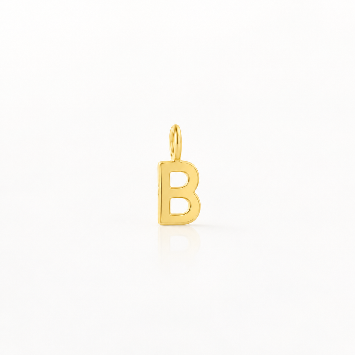 A polished gold initial letter 'B' charm pendant with a small top loop, shown on a clean white background with a soft reflection below.