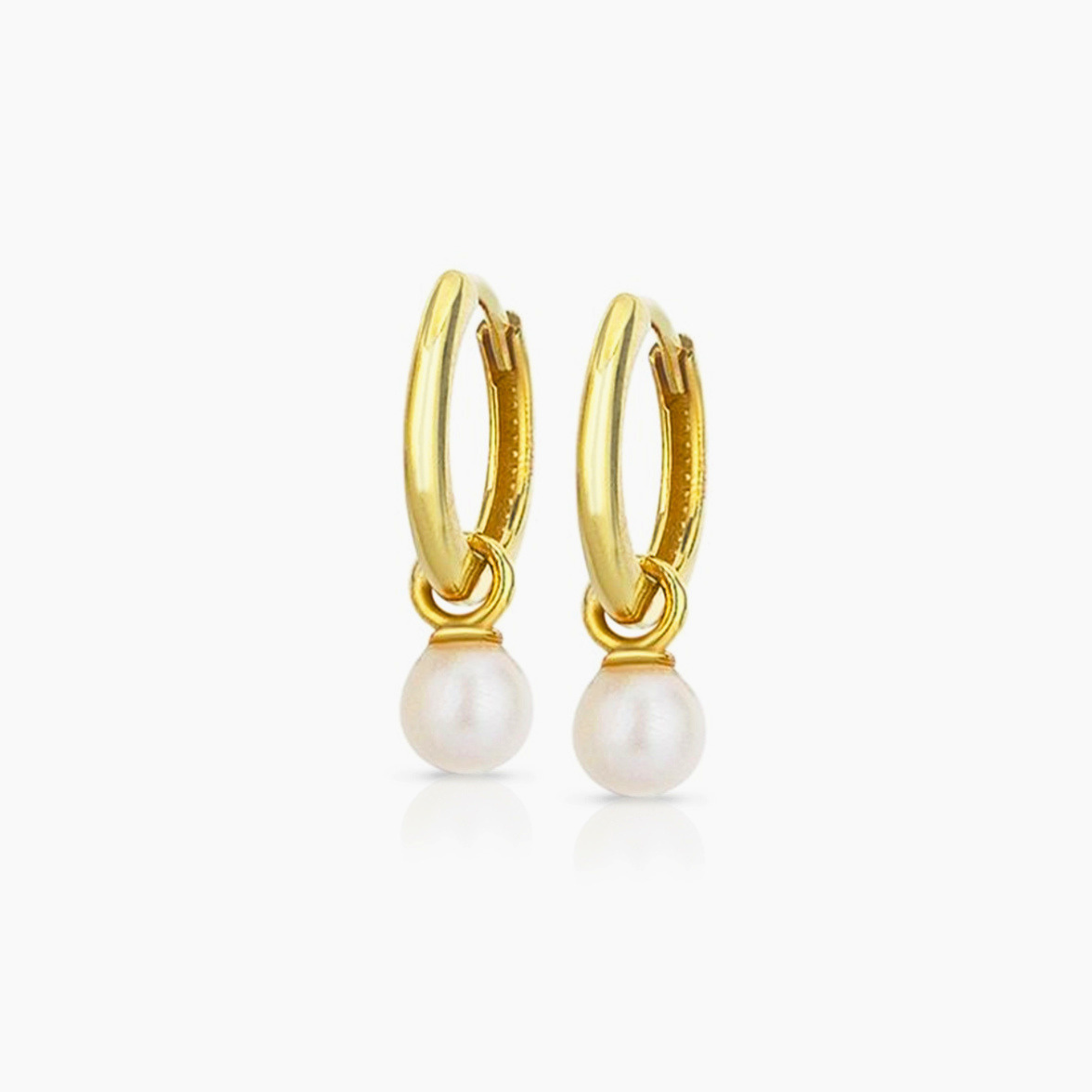 Gold hoop earrings with pearl drops on a white background