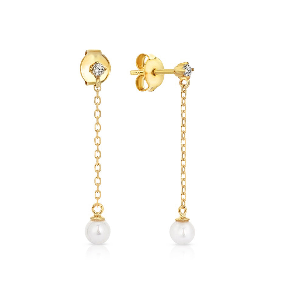 Gold earrings with pearl drops on a white background