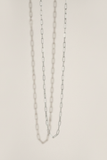 Silver chain necklace on a light beige background