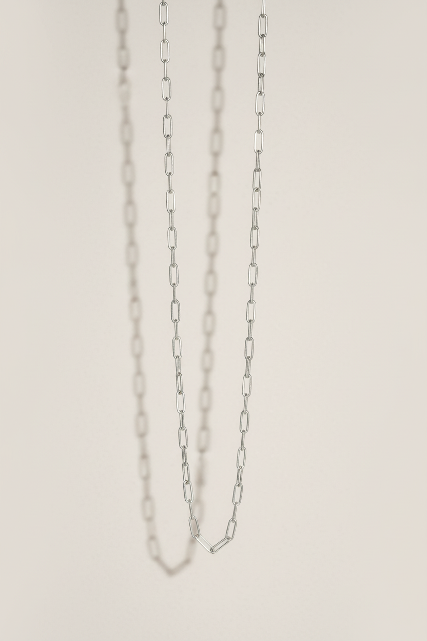 Silver chain necklace on a light beige background